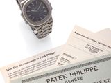 a wrist watch and a certificate sitting on top of a table
