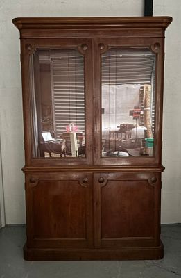 a wooden cabinet with a glass door in the corner