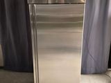 a stainless steel refrigerator in a room with a curtain
