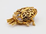 an image of a gold turtle broochle on a white surface