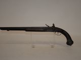 an old gun on a clear stand on a white surface