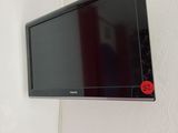 a flat screen tv mounted on the wall above a bed
