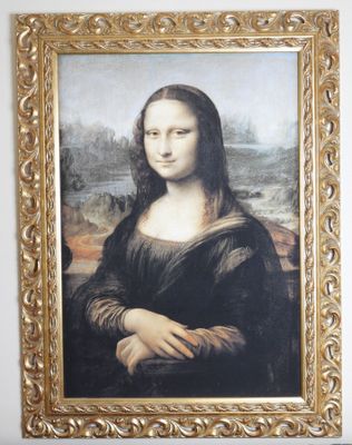a picture of a painting of a woman in a gold frame on the wall