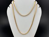 un collier à chaîne en or sur un présentoir à mannequin