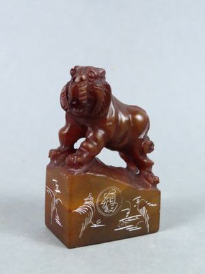 deux figurines chinoises sculptées représentant un lion sur un rocher