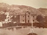 an old photo of a large house with a fountain in front of it