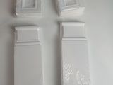 quatre morceaux de plastique posés sur une surface blanche