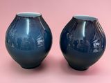 two blue vases on a pink background with a pink background