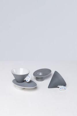 deux bols et une assiette avec une cuillère posés sur une table blanche