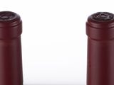 three bottles of wine are lined up in a row on a white surface
