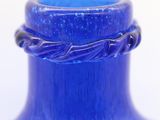 a blue glass vase with a braid handle on it