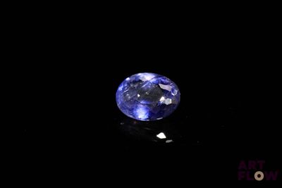 a close up of a blue sapphire stone on a black surface