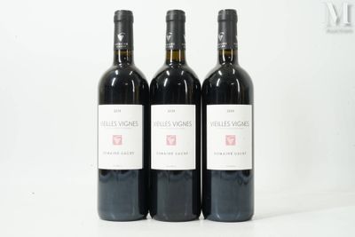 three bottles of red wine sitting on top of a white table