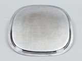 a close up of a silver plate on a white surface