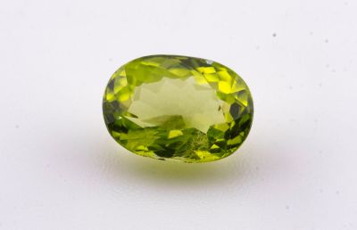 un gros plan d'une pierre précieuse verte sur une surface blanche