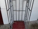 a metal cage with a red platform on the floor