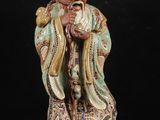 une figurine chinoise représentant un vieil homme tenant un bâton