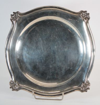 an antique silver plate on a stand on a white background