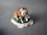 a figurine of a dog that is sitting on a rock