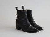 une paire de bottines en cuir noir sur fond blanc