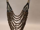 a close up of a necklace on a stand on a white background