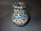 a small vase with a colorful design on it on a table