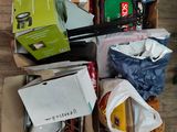 un carton rempli d'objets posé sur un plancher en bois