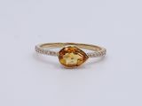 a close up of a gold ring with a citrine stone and diamonds