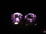 une paire d'améthystes violettes posées sur une surface noire