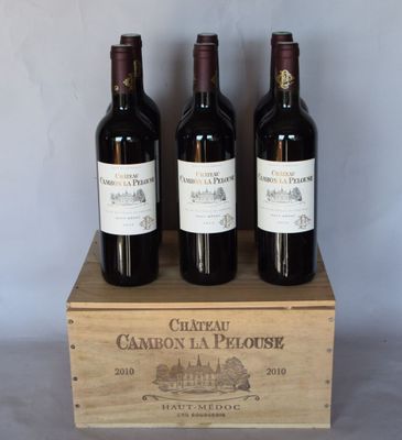 trois bouteilles de vin rouge dans une caisse en bois posée sur une table