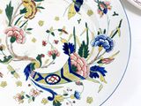 two plates with colorful designs on them on a table