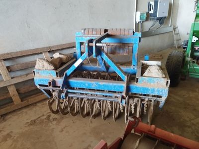 a blue machine that is sitting in the dirt
