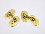 a pair of gold plated cufflinks on a white background