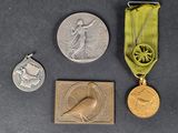 three medals and a medal on a table with a green ribbon