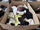 a cardboard box full of clothes and shoes on the floor