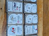 Plusieurs disques durs sont empilés les uns sur les autres sur une surface en bois