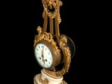 a clock that is sitting on a pedestal on a black background