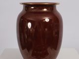 a brown vase sitting on a table with a white background