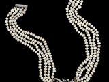 un collier de perles à trois rangs muni d'un fermoir en diamant