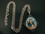 une image représentant un collier orné d'une photo d'une femme tenant un chat