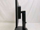 a computer monitor and speaker on a stand on a white surface
