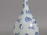 a blue and white vase sitting on a gray surface