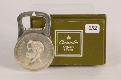 a bottle opener with a coin on it next to a box of cigarettes