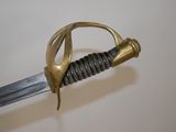 a close up of a sword with a gold handle