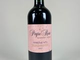 a close up of a bottle of wine on a white surface
