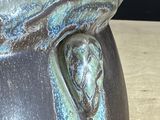 a close up of a vase on a table with a black background