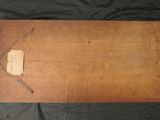 an old wooden box with a tag on it sitting on a black cloth