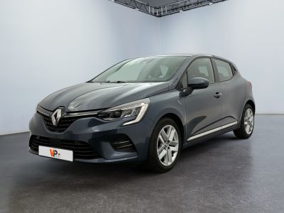 Une voiture grise est garée dans une pièce aux murs blancs.