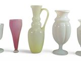 several different colored vases are lined up on a white surface
