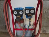 deux bouteilles de gaz posées sur un chariot, reliées par un tuyau
